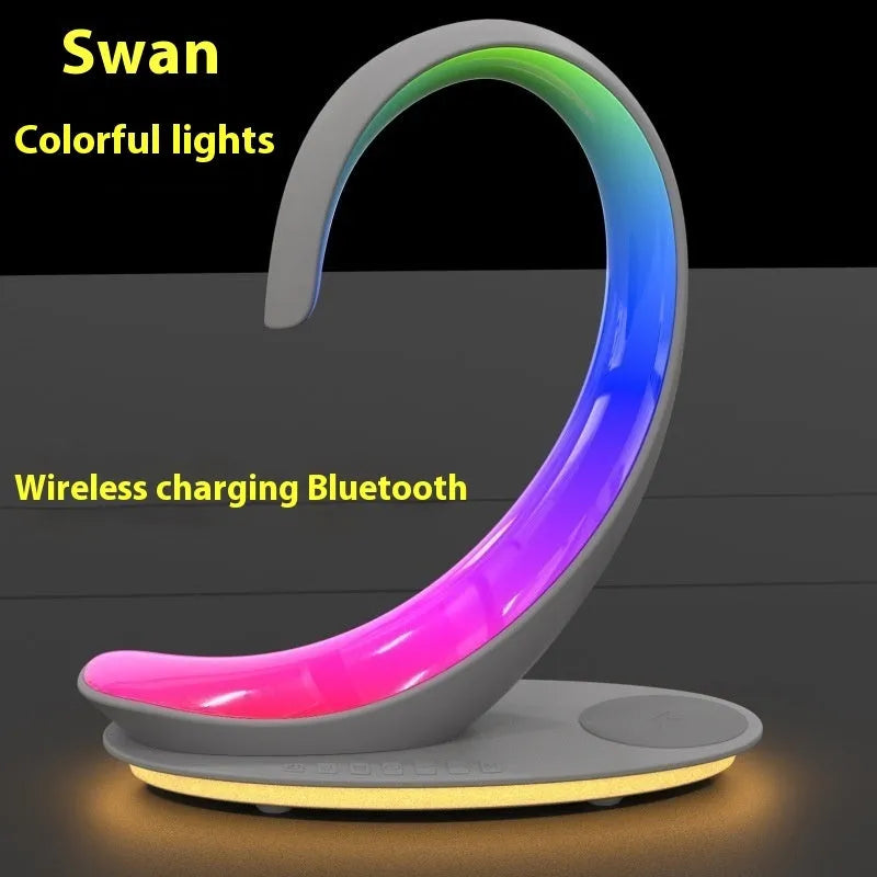 White swan-shaped desktop device functioning as a wireless charger, Bluetooth speaker, and colourful LED atmosphere lamp.