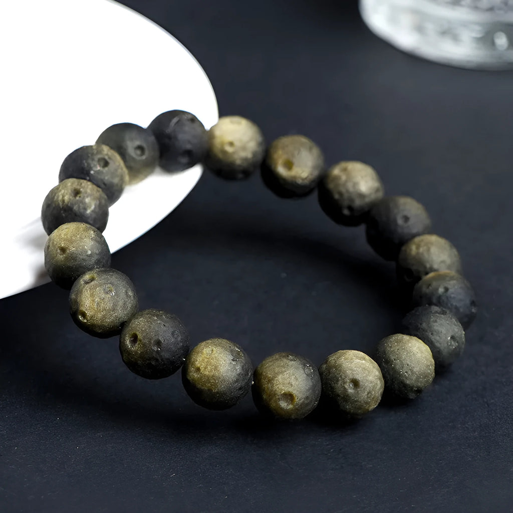 Unisex natural obsidian crater ball bracelet in silver stone meteorite colour with textured beads.