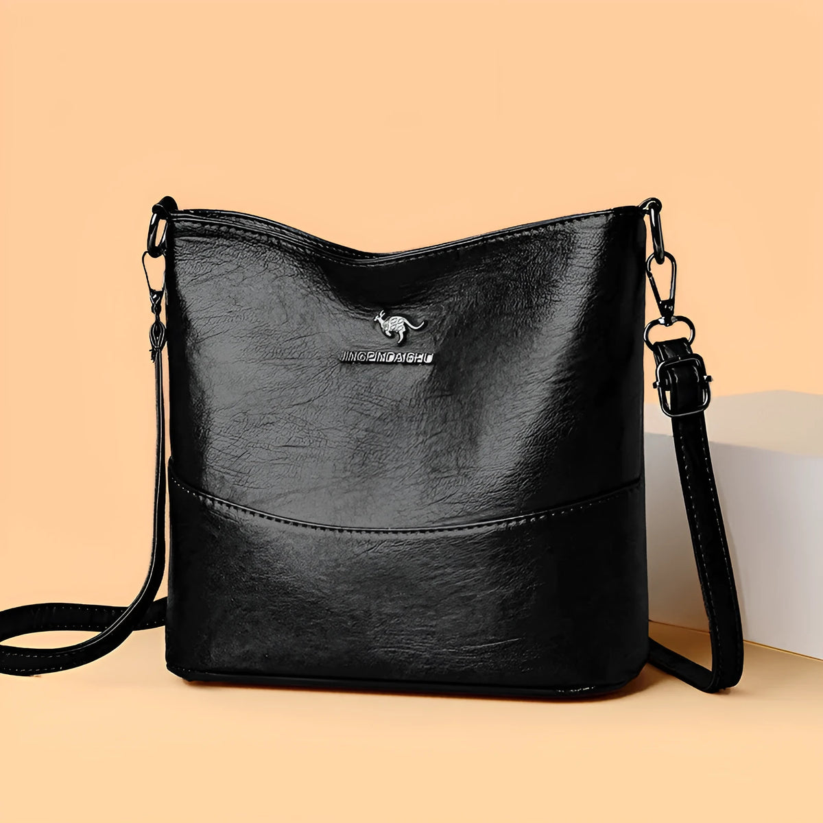 Women's soft leather bucket shoulder bag in solid colour with sewing line details and organisational pockets