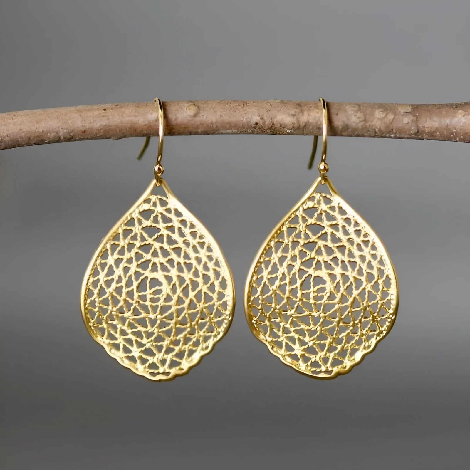 Gold-coloured alloy drop pendant earrings with a detailed retro leaf hollow design.