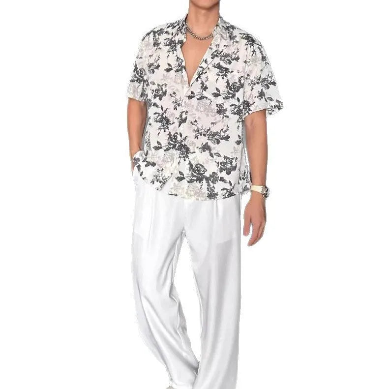 Loose-fitting black floral print short sleeve shirt on a hanger.