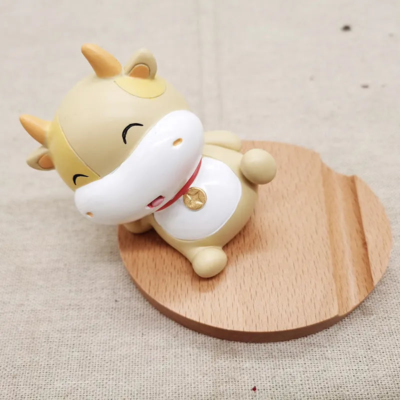Solid beech wood phone holder with resin puppy decoration and a pound coin in the integrated slot.