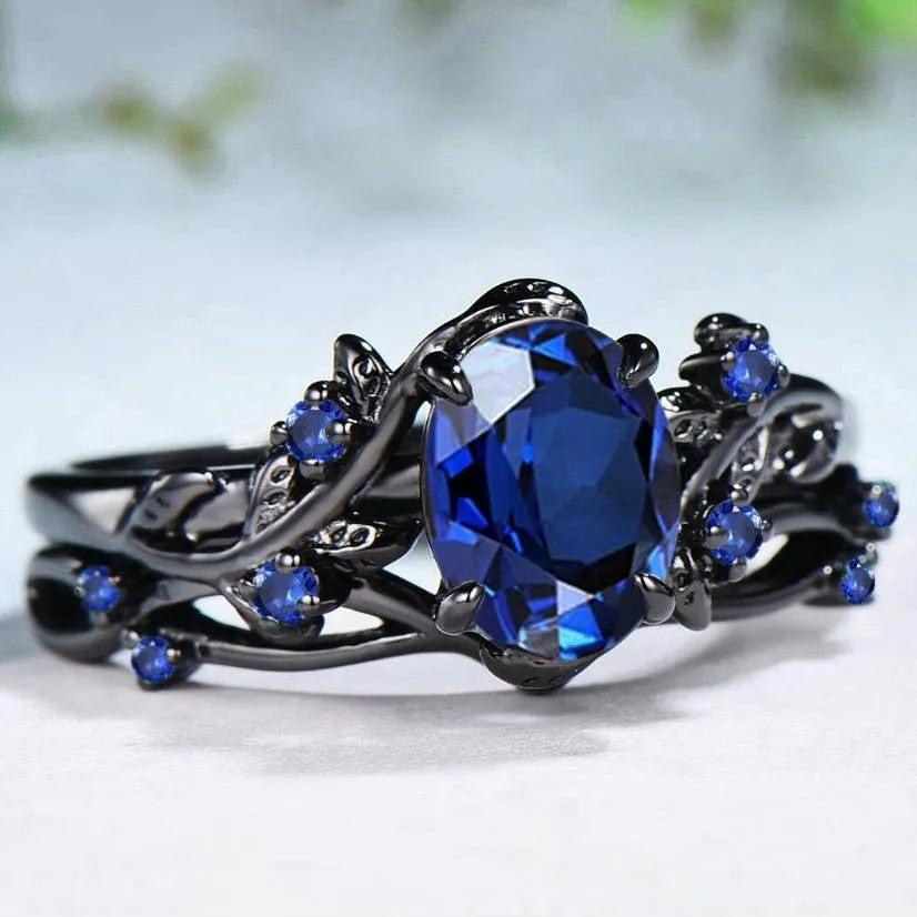 Geometric gun black couple ring for women with a single inlaid navy blue rhinestone.