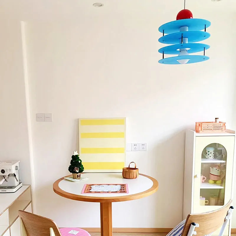 Macaron-shaped adjustable chandelier light fixture with a frosted shade, shown in a dining setting.