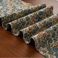 Nordic striped jacquard table runner with tassel on a dark wooden dining table.