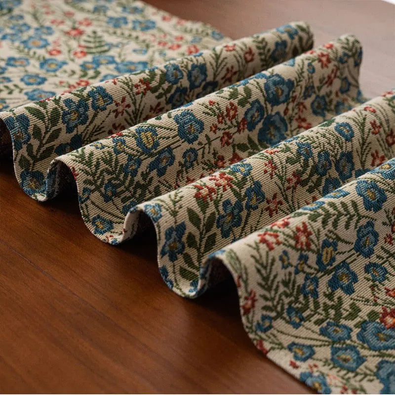 Nordic striped jacquard table runner with tassel on a dark wooden dining table.