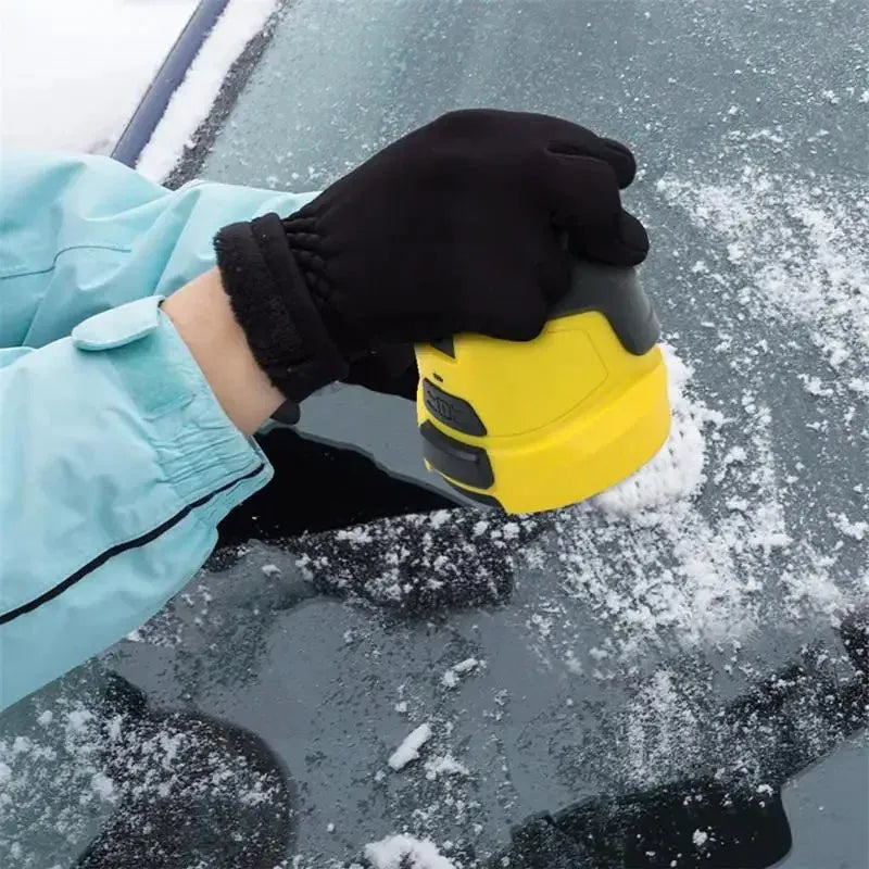 Yellow cordless electric car ice scraper with USB charging cable on a frosty car windscreen.