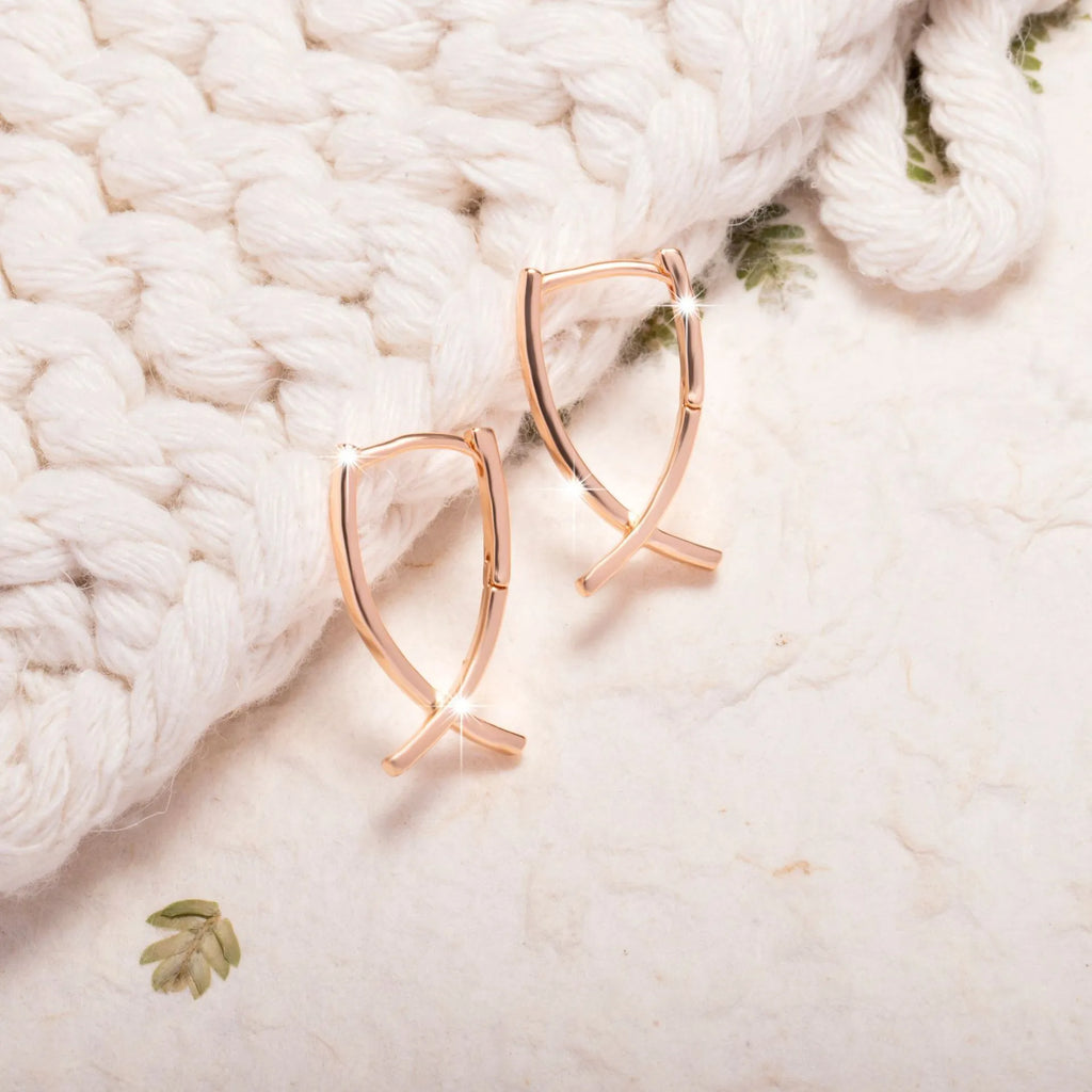 Rose gold plated cross earrings on a white background, showing post and clutch fitting.