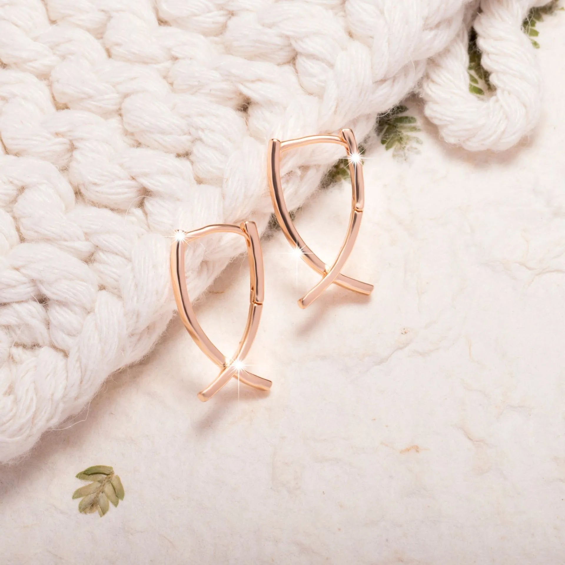Rose gold plated cross earrings on a white background, showing post and clutch fitting.