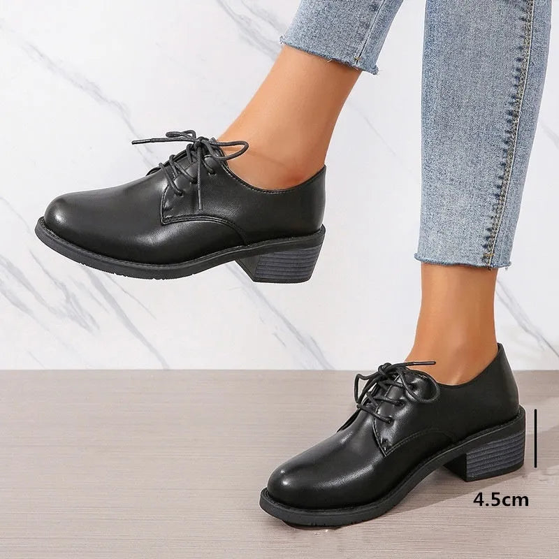 Black women's low-top work shoes with a chunky mid heel and rubber sole.