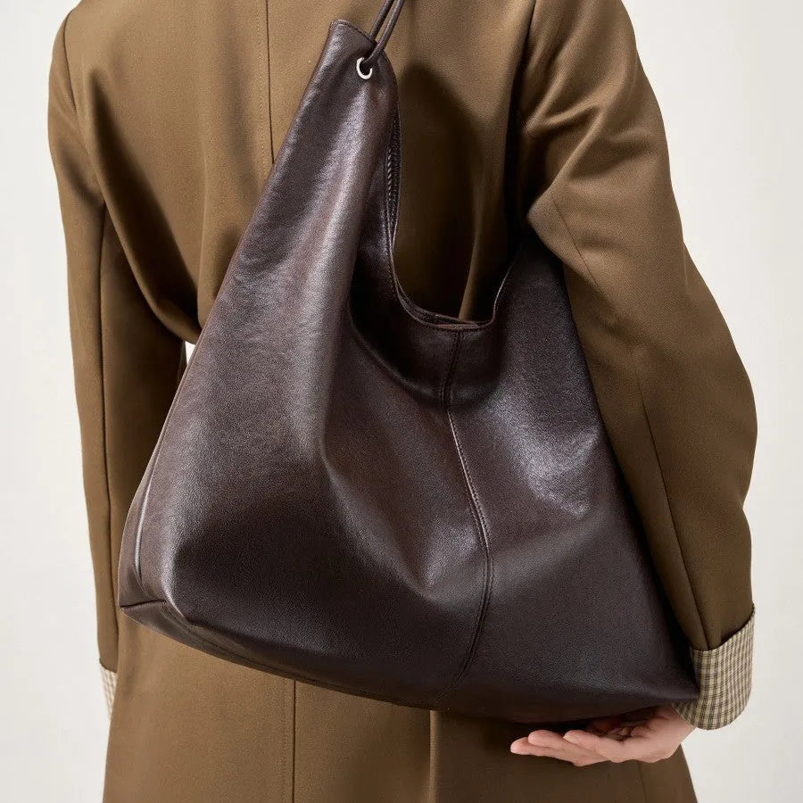 Brown genuine leather tote bag with contrast stitching and large capacity, front view on white background