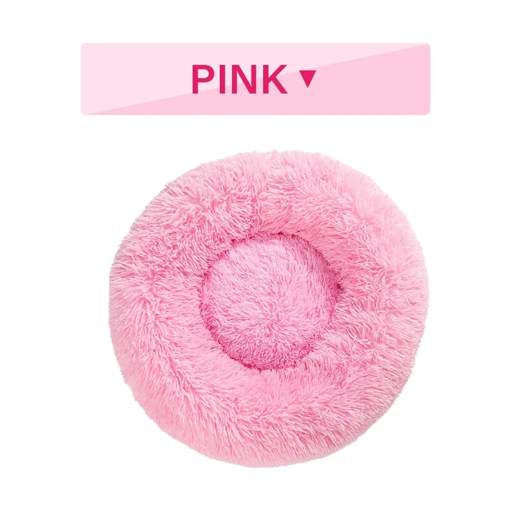 A fluffy, round donut-shaped dog bed with a raised rim in long plush fabric.