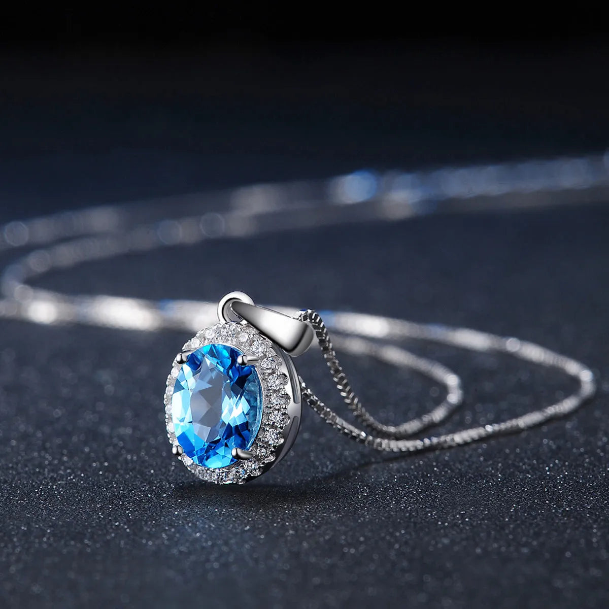 Geometric women's jewellery set in sterling silver with blue topaz gems, showing necklace, earrings, ring, and pendant.
