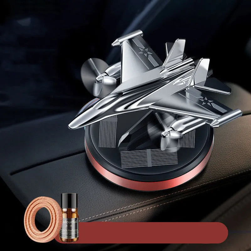 Solar powered rotating fighter aircraft perfume ornament in silver, gold, blue, or red colour.