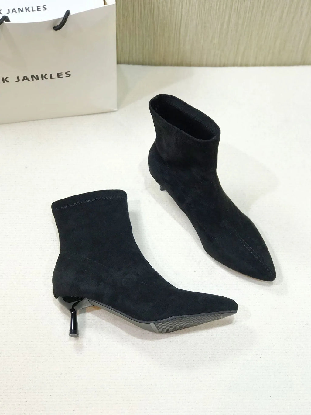Black pointed toe women's ankle boots with a stiletto heel on a mid-calf shaft.
