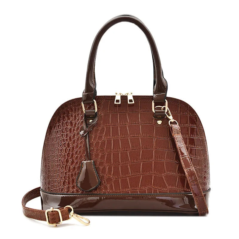 Shiny black PU shoulder bag with crossbody strap showing shell-shaped structure