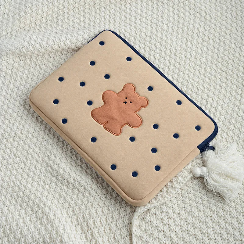 Embroidered animal design laptop sleeve in polyester, shown next to a laptop.