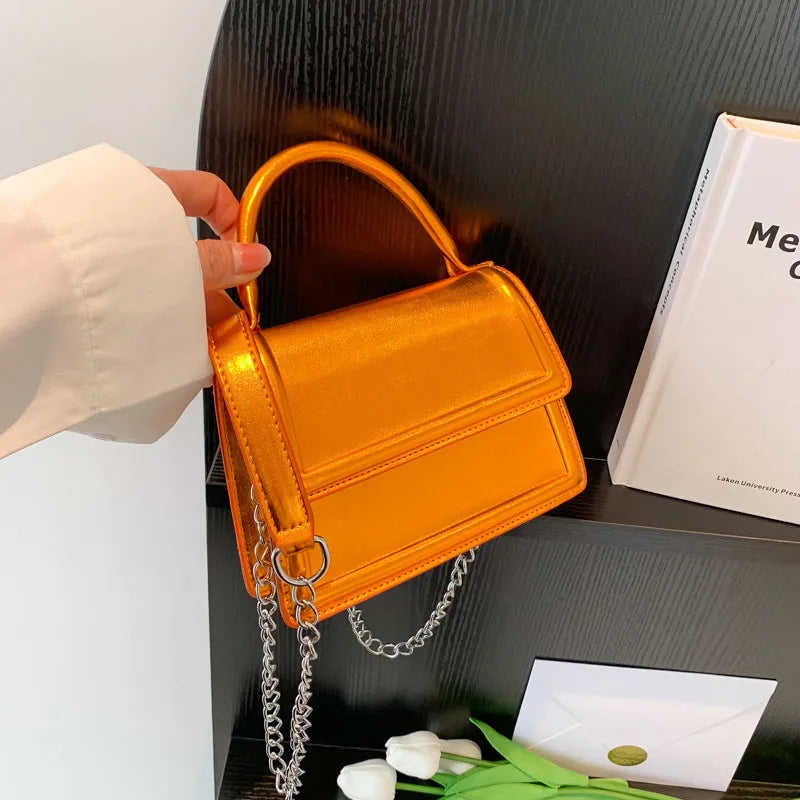 Retro shoulder bag in horizontal square shape with crossbody strap and sewing line detail