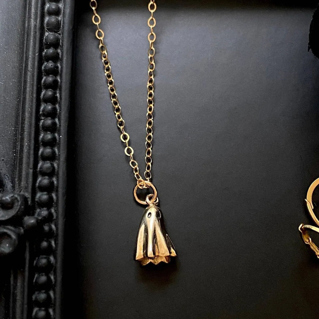 A modern ghost pendant necklace on a stainless steel chain, showing the titanium steel electroplated pendant detail.