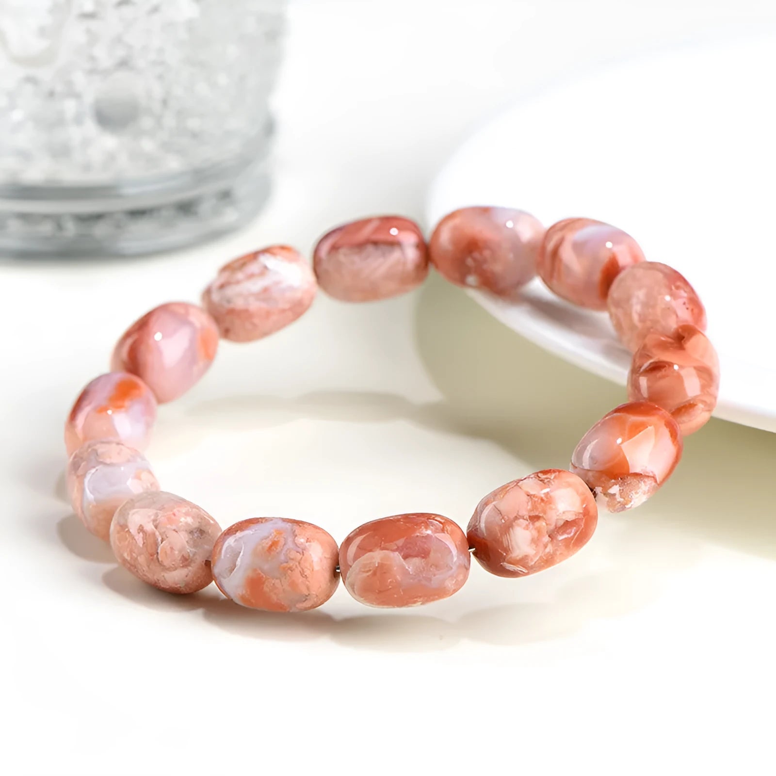 Natural cherry agate bracelet with barrel-shaped beads and a Ruyi design element on a wrist.