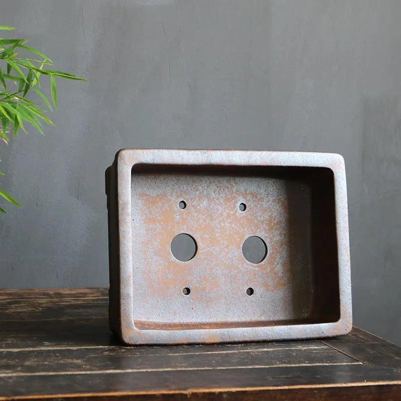Rectangular purple sand bonsai pot with shallow basin, shown empty on a wooden surface.