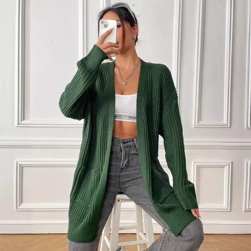 Women's dark green loose-fit acrylic knit cardigan with long sleeves on a hanger.