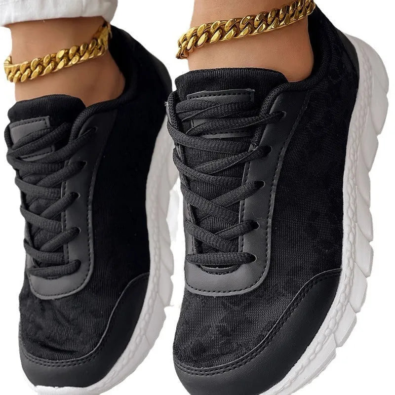 Women's white canvas running shoes with a flat heel and soft sole on a plain background.