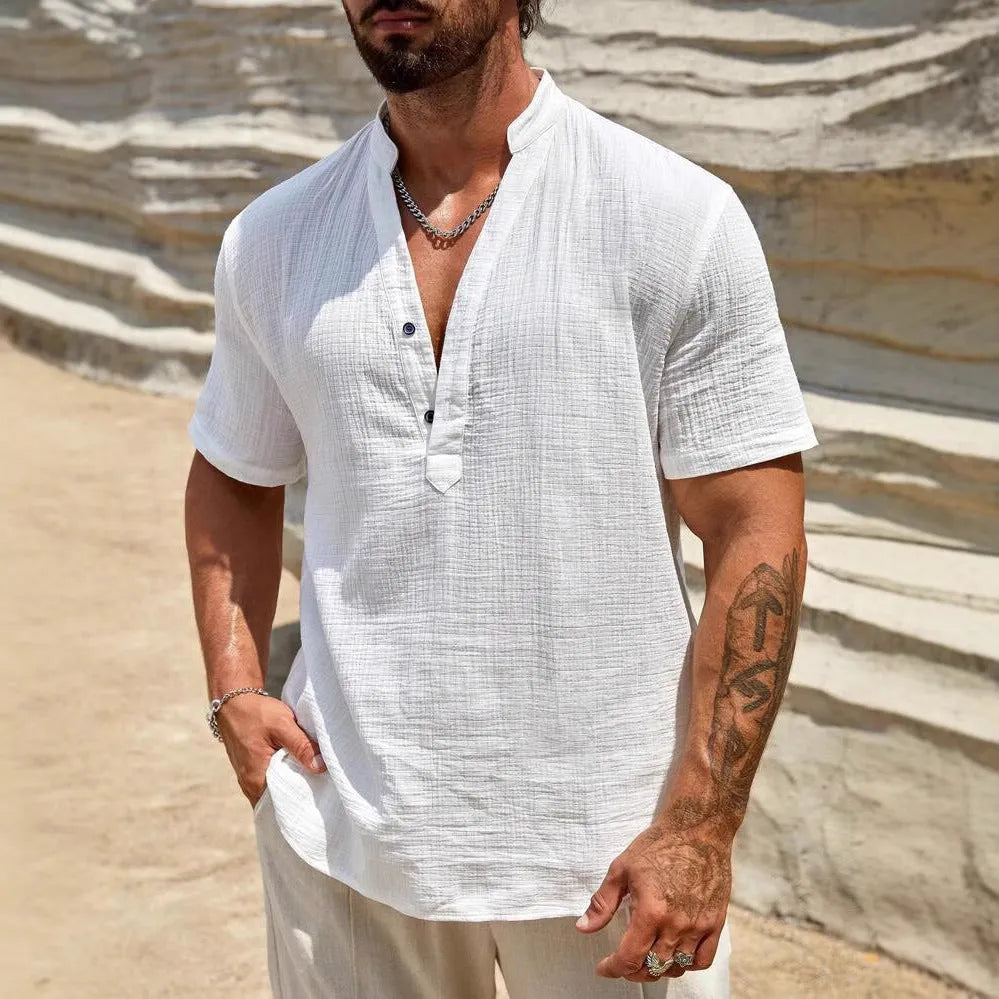 Man wearing a thin light blue stand collar short-sleeved casual shirt.