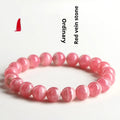 Women's geometric rhodochrosite crystal bracelet with a longevity lock clasp on a wrist.