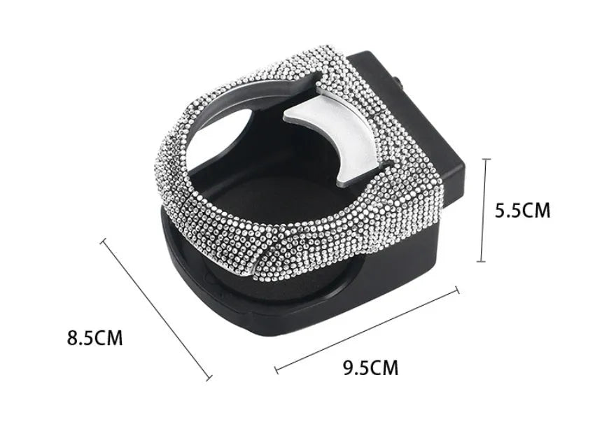White diamond encrusted car cup holder bracket mounted on a vehicle air vent.