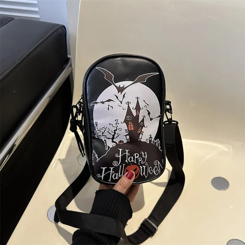Black Halloween crossbody bag with orange pumpkin, white ghost, and black bat print, showing front zip and adjustable strap.