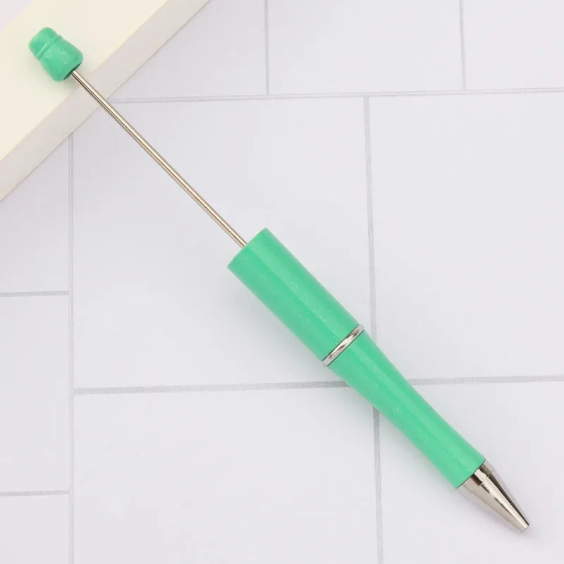 Colourful spinning ballpoint pen with plastic beads on a white background.