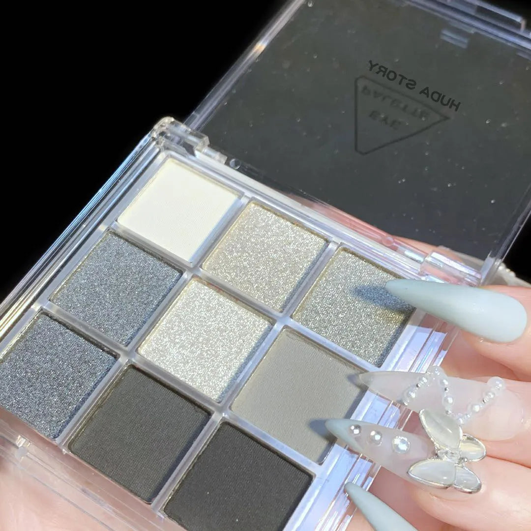 Open compact case showing nine powder eye shadow pans in neutral and smoky shades.