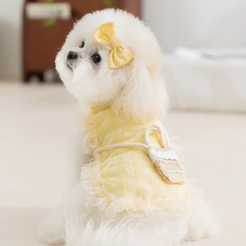 Two-tone sleeveless pet outfit in yellow or blue with ruffles, matching bow and small woven crossbody bag.