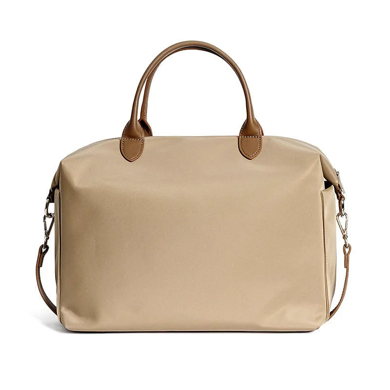 Black waterproof nylon shoulder bag with leather detailing showing large main compartment