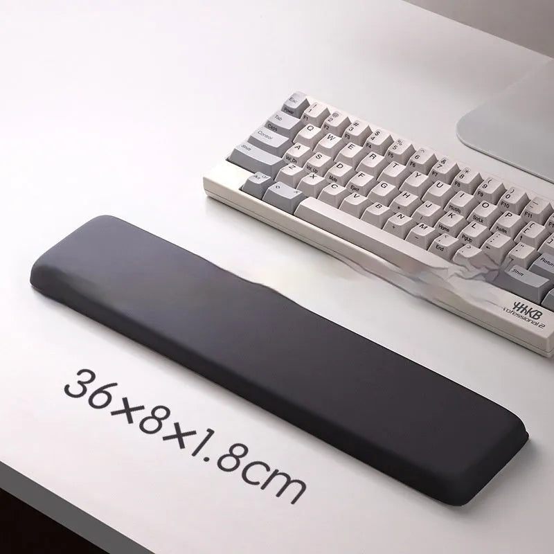 Square black silica gel mouse pad with raised keyboard support area and integrated wrist rest on a wooden desk.