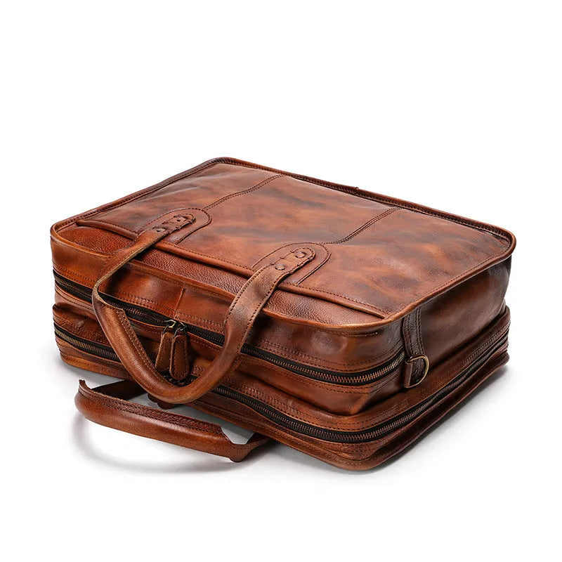 Brown vintage leather men's briefcase open showing internal laptop sleeve and multiple organisation pockets