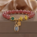 Red strawberry quartz beaded bracelet with metal alloy setting and sparkling rhinestone details.