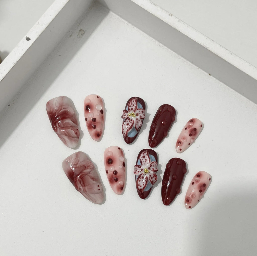 Hand-painted 3D carved manicure nail set showing rose, tulip and butterfly patterns in medium almond length