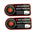 A pair of white rectangular Tesla Sentry Mode warning stickers with black text, measuring 11cm by 5cm.