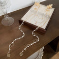 Gold tone acrylic hairpin with pearl diamond flowers and long tassel design
