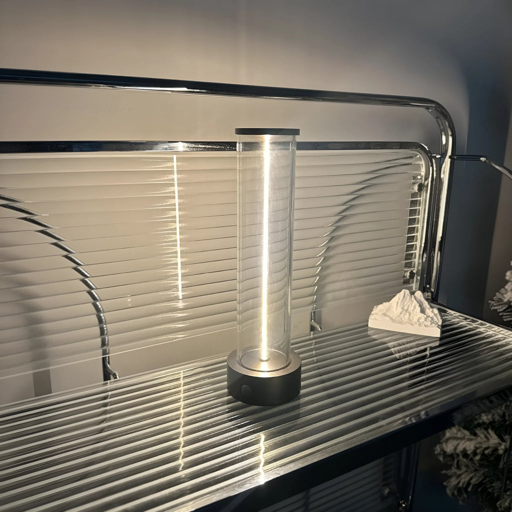 Slim modern glass LED bar night light with magnetic base on a desk surface.