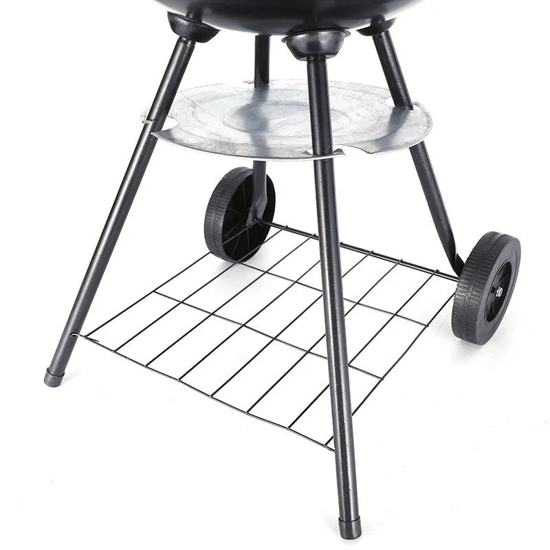 Portable round iron barbecue grill with 14-inch cooking grate, shown on a patio.