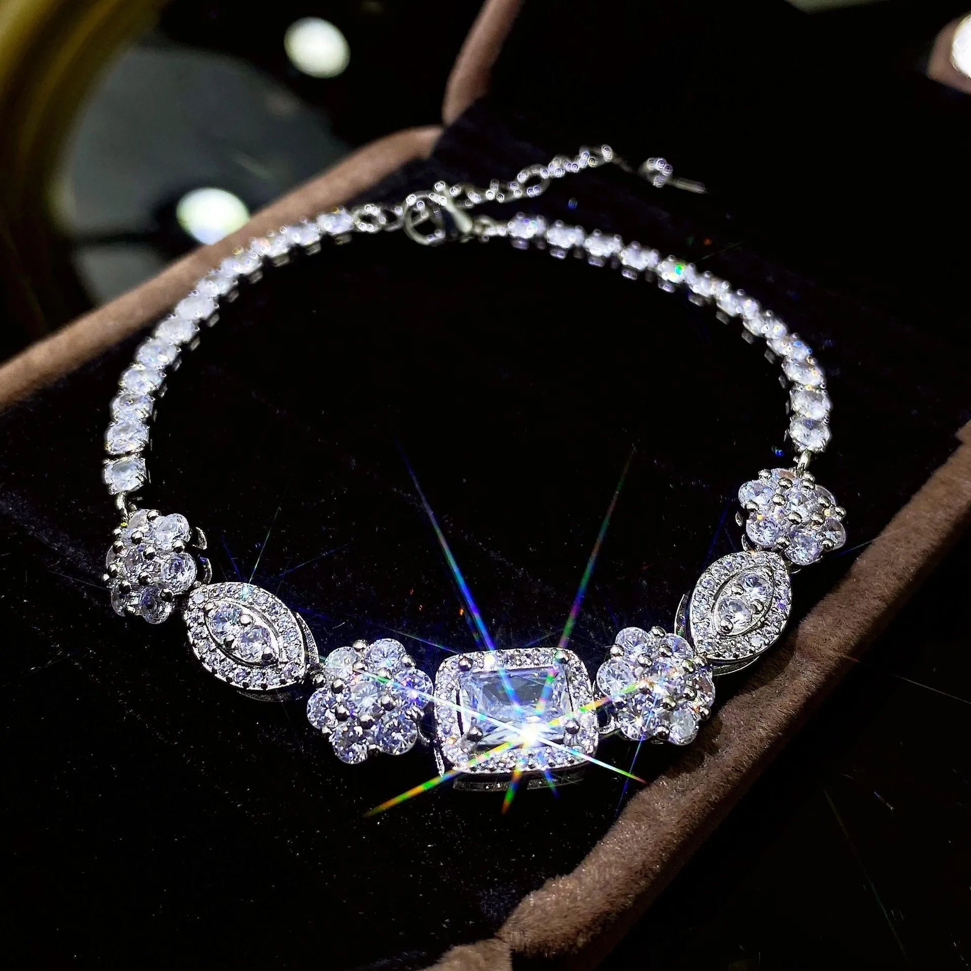 Close-up of women's geometric silver bracelet with inlaid zircon stones on a wrist, showing adjustable chain links.