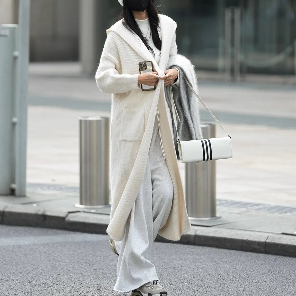 Long grey knitted cardigan with a hood and trench coat style, shown unbuttoned.