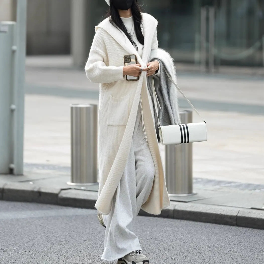 Long grey knitted cardigan with a hood and trench coat style, shown unbuttoned.