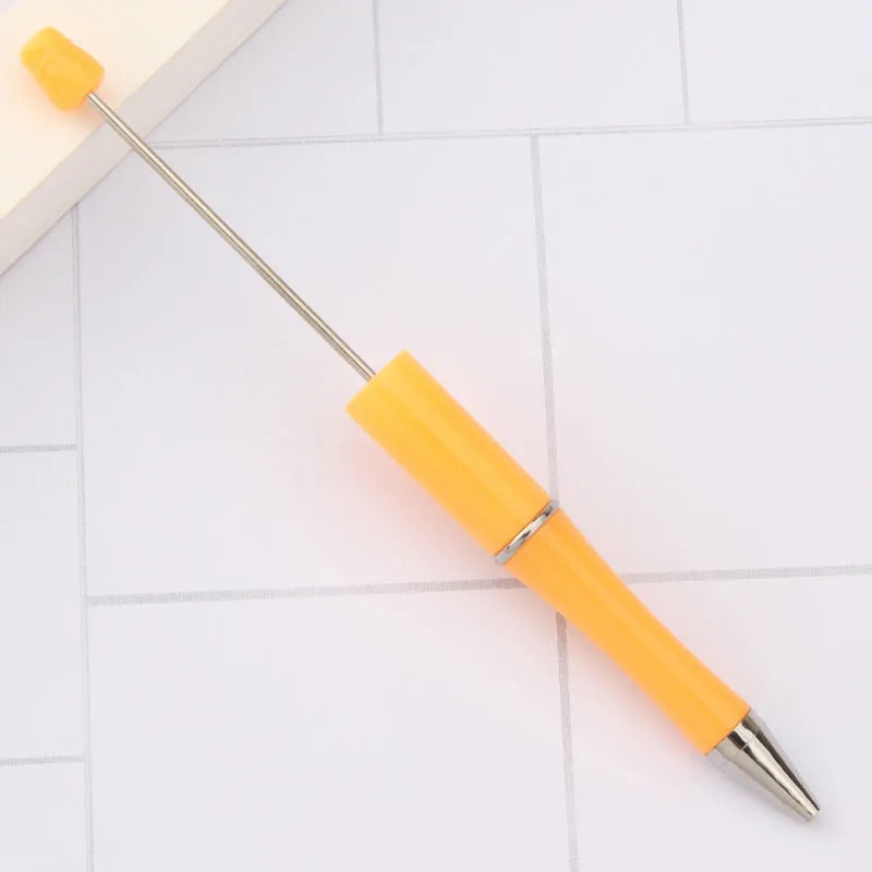 Colourful spinning ballpoint pen with plastic beads on a white background.