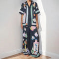 Black women's casual set with cartoon print, featuring a cardigan and trousers.