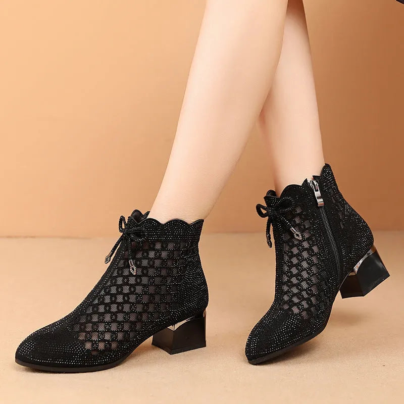 Black women's ankle boots with cutout mesh panels, mid heel, side zipper, and rhinestone sequin details