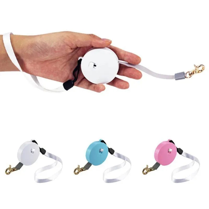 Retractable dog lead with 2m nylon tape, lock button, and non-slip handle in white, pink, or blue.
